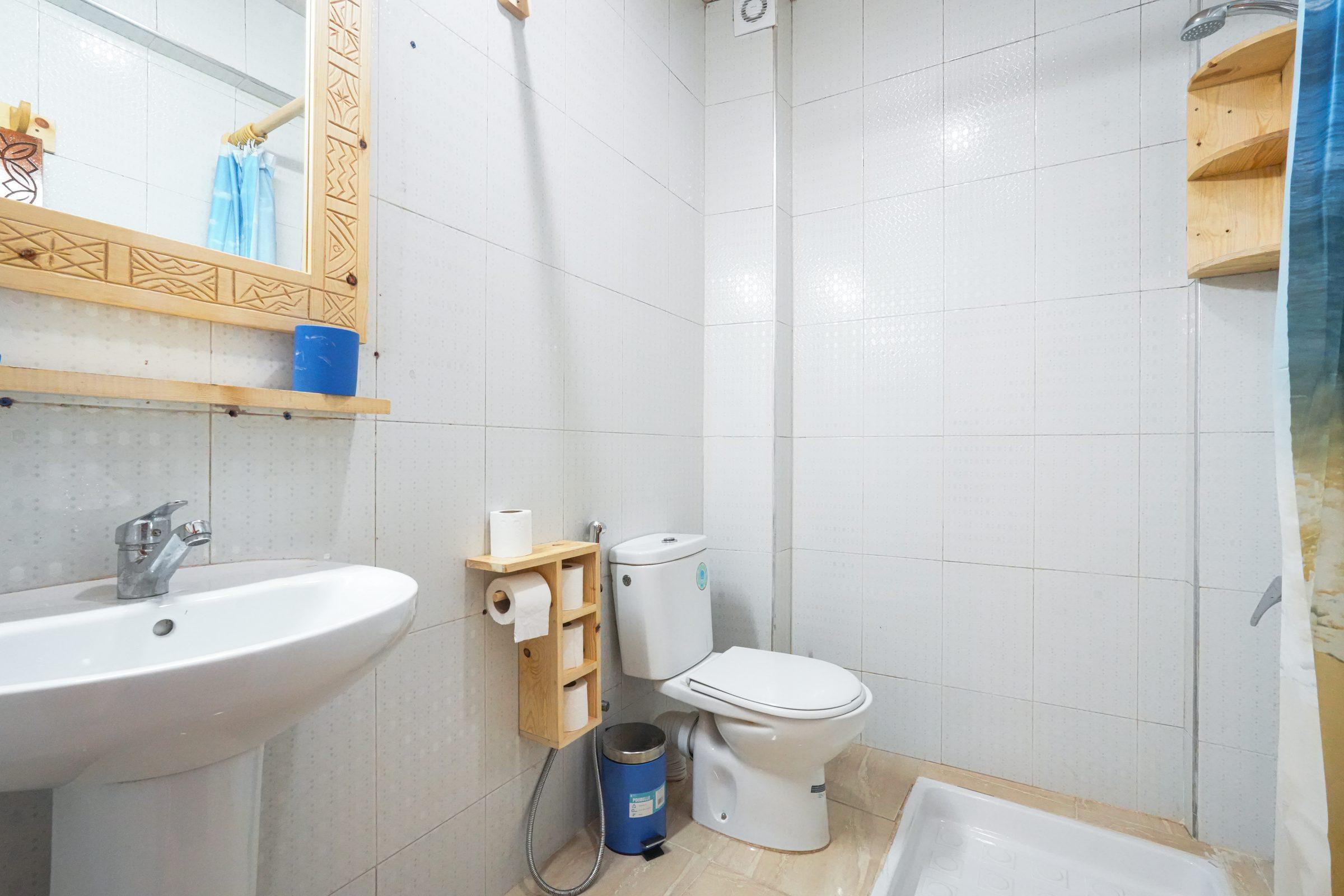 Bathroom with mirror and wooden shelving
