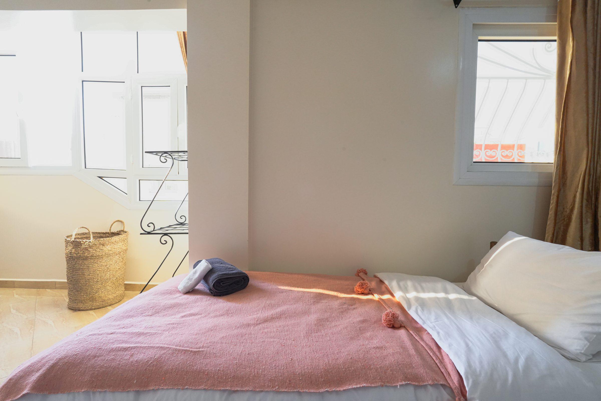Bedroom with warm pink walls and iron bed frame